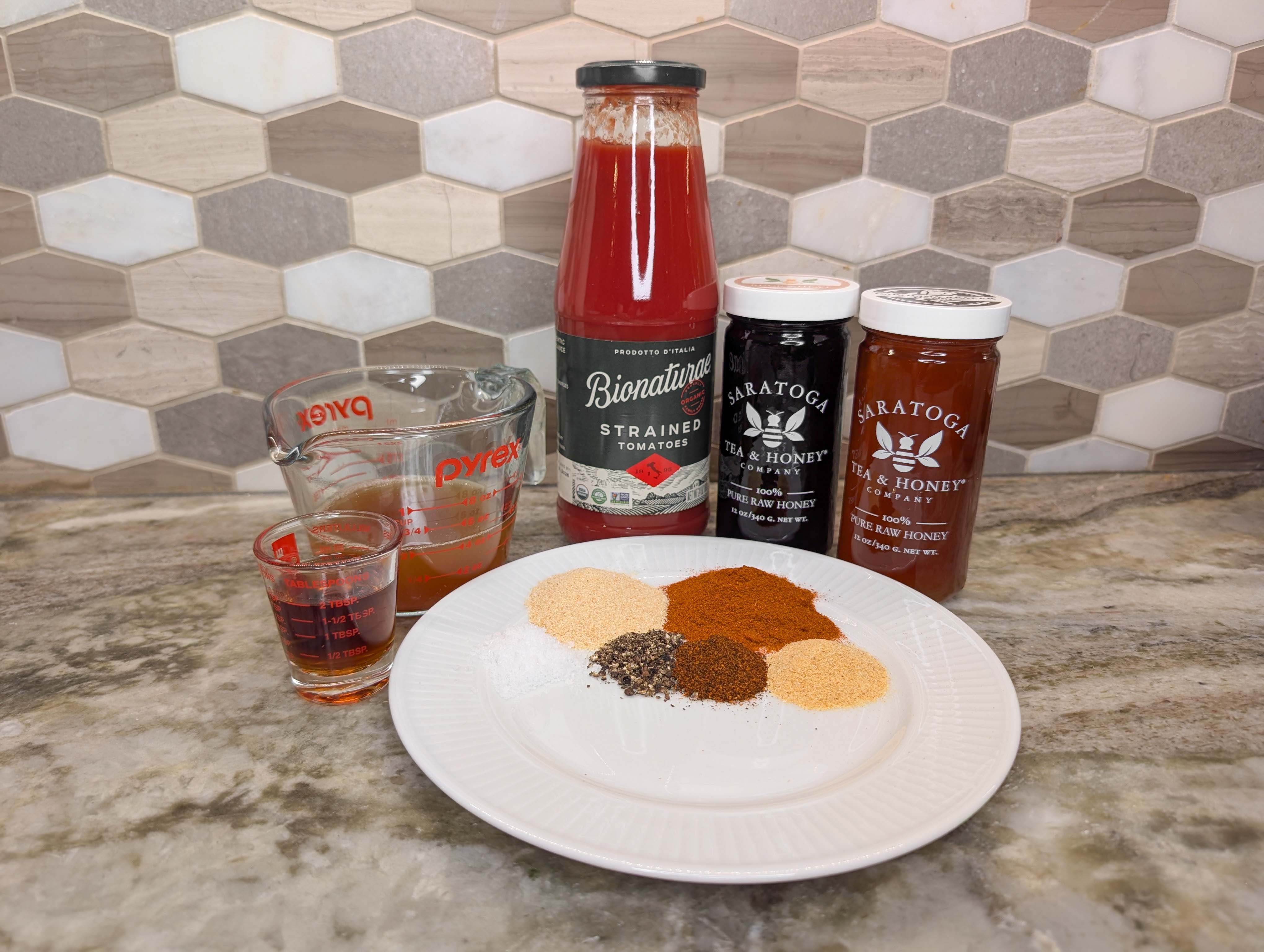 Ingredients for a homemade honey barbecue sauce on a kitchen counter.