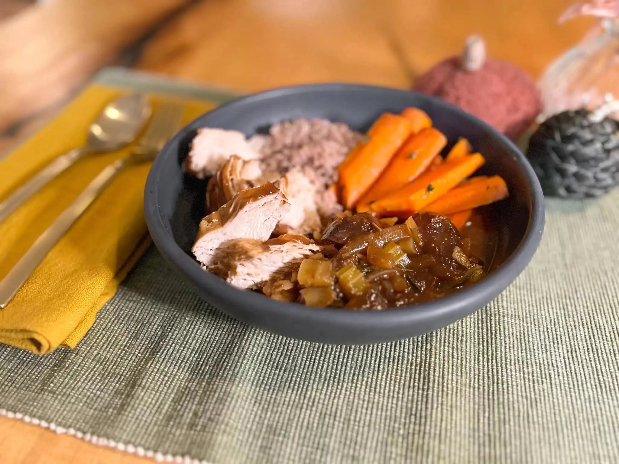 chicken tagine in a dark blue pasta bowl served with rice and carrots