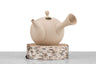 sand colored side handled kyusu sitting on a wood block