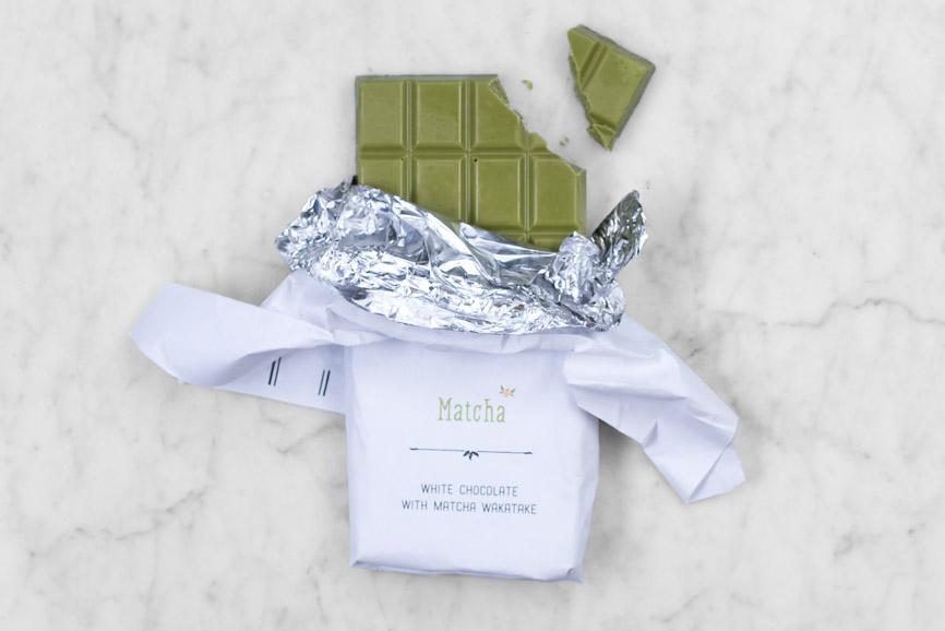 open bar of matcha white chocolate with a piece broken off
